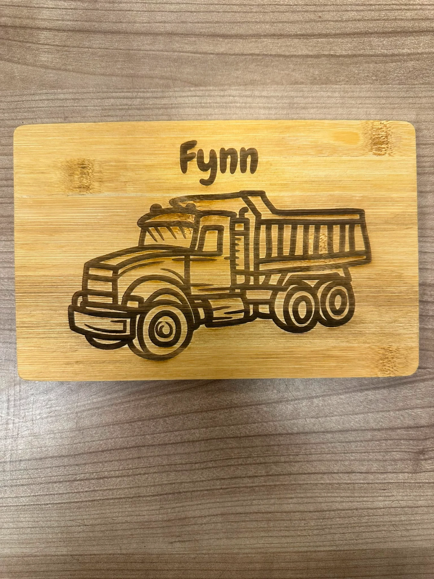 Wooden board with engraved name and truck motif