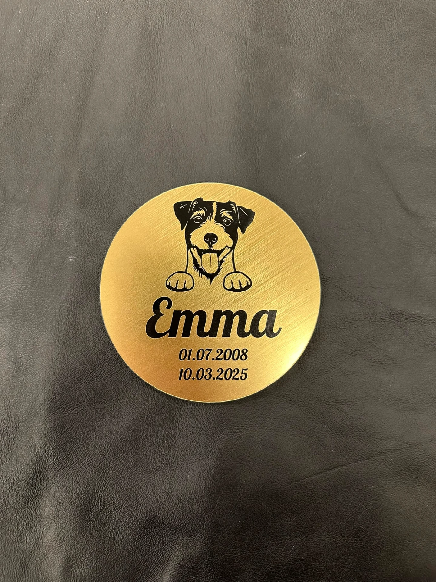 Round brass plaque with engraved dog portrait, name and details